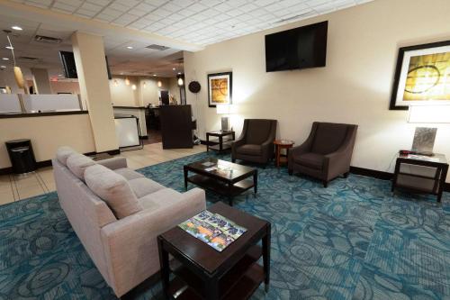 a lobby with a waiting room with a couch and chairs at Quality Inn & Suites Downtown Mansfield in Mansfield