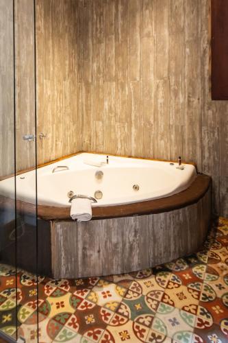 Una bañera colocada encima de un suelo. en Hotel Ascona, en Campos do Jordão
