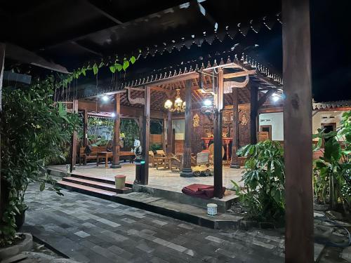 a wooden house with a porch with a table at Homestay Joglo Kembar in Gading