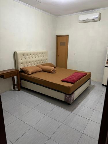 a bedroom with a large bed in a room at Homestay Joglo Kembar in Gading