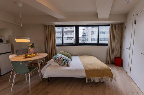 a bedroom with a bed and a table and window at Mi-Hotel Kameido in Tokyo