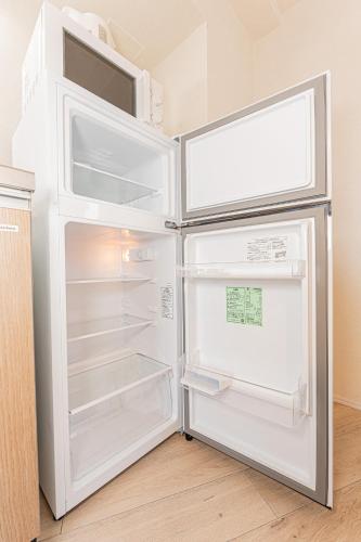 an empty refrigerator with its door open in a kitchen at Mi-Hotel Kameido in Tokyo