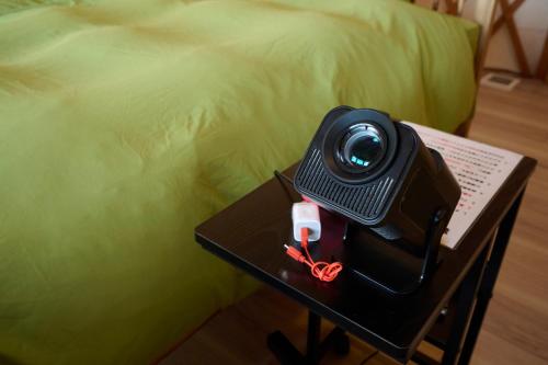 kamera na stole obok łóżka w obiekcie フォレスタ阿蘇車帰 w mieście Aso