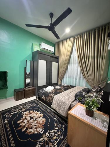 a bedroom with a bed and a ceiling fan at Reisya Homestay in Kepala Batas