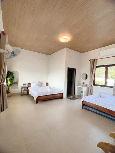 a large bedroom with two beds and a ceiling at Mộc House in Ninh Hải