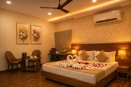 a hotel room with a bed with two swans on it at Grand Maalyasa Hotel and Suites, US Consulate Hyderabad 2 Mins walk in Hyderabad