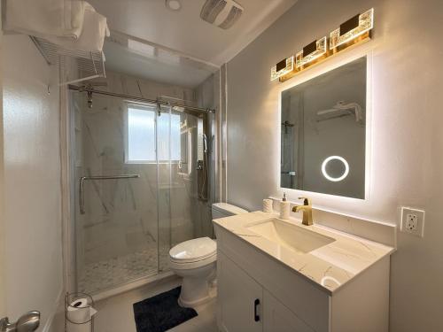 a bathroom with a toilet and a sink and a shower at Spacious 2 BR Suite with Parking, Backyard & Desk in Toronto