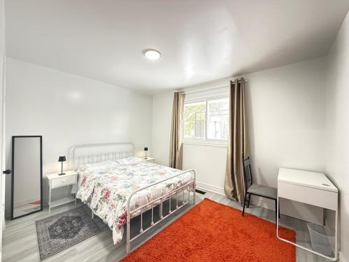 a white bedroom with a bed and a window at Spacious 2 BR Suite with Parking, Backyard & Desk in Toronto