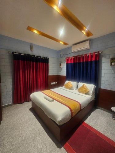 a bedroom with a large bed with red curtains at Narmada homestay Yamuna in Malappuram