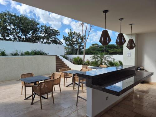 a kitchen and dining area with tables and chairs at Otoch Departamento EN MÉRIDA in Mérida