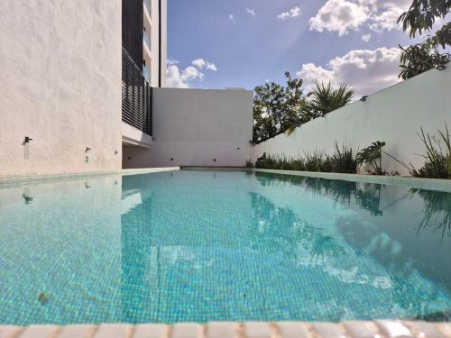 a swimming pool in front of a building at Otoch Departamento EN MÉRIDA in Mérida