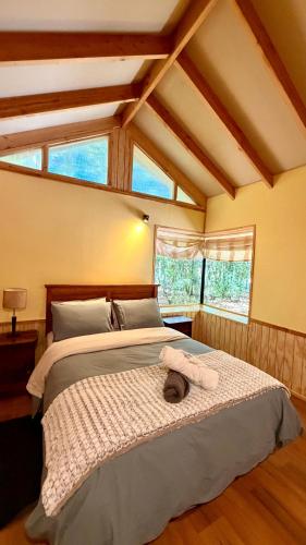 a bedroom with a bed with two towels on it at Cabaña Roca Volcán in Melipeuco