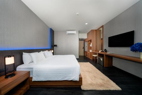 a hotel room with a bed and a flat screen tv at Happy Hotel Aonang Krabi in Ao Nang Beach