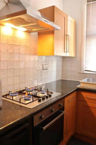 a kitchen with a stove top oven in a kitchen at Perfect Getaway 2 bedroom house with parking in Beeston Hill