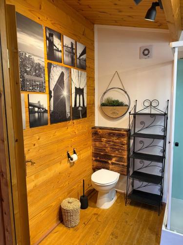 a bathroom with a toilet and pictures on the wall at São Jorge Spot - Alojamento in Velas
