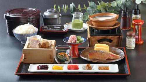 a table topped with a tray of food with plates of food at Hotel Binario Saga Arashiyama in Kyoto
