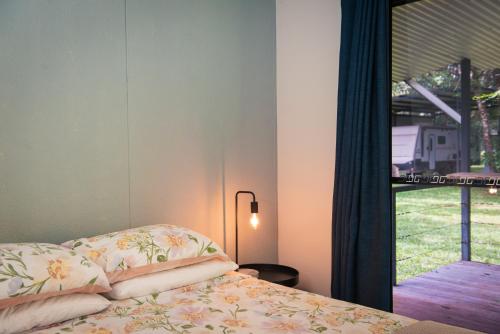 a bedroom with a bed with pillows and a window at Banyan Tree Holiday Park in Rum Jungle Station