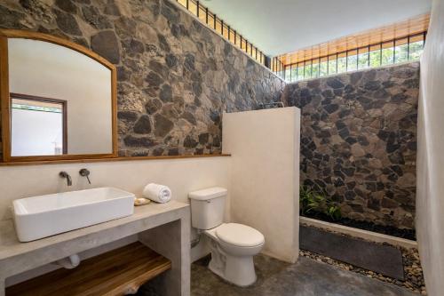 a bathroom with a sink and a toilet and a mirror at Calma Ometepe in Santa Cruz