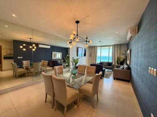 a dining room and living room with a glass table and chairs at Departamento con acceso directo a la playa en Velamar in Altamira