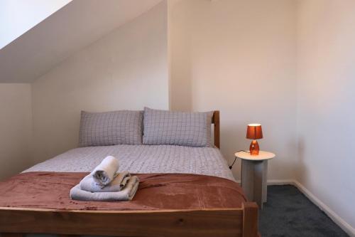 a bedroom with a bed with a towel on it at Perfect Getaway 2 bedroom house with parking in Beeston Hill