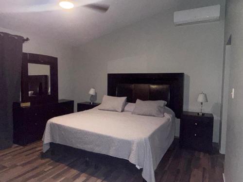 a bedroom with a large white bed with two night stands at Casa Serena in Hermosillo