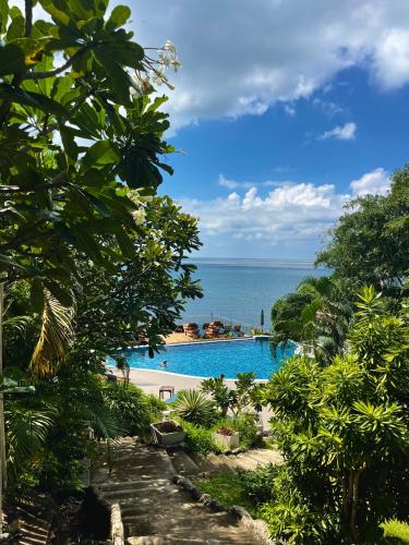 a swimming pool with the ocean in the background at Pinnacle Koh Tao Resort in Ko Tao