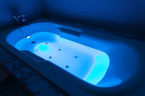 y baño con bañera con luz azul. en Hotel Moana Otsuka (Adult Only), en Tokio
