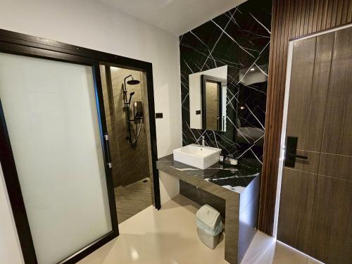 ein Badezimmer mit Waschbecken und Spiegel in der Unterkunft Hotel Le Naga in Sakon Nakhon