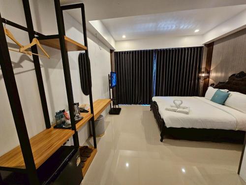 ein Schlafzimmer mit einem Bett und einem Fernseher in der Unterkunft Hotel Le Naga in Sakon Nakhon