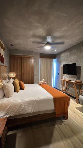 a bedroom with a large bed with a ceiling fan at Amplio Estudio con Balcon Tuk 004 in Tulum