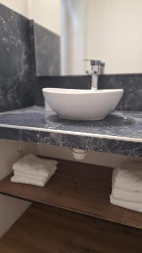 a bathroom counter with a white bowl on a sink at Hospedaje Sierras Chica in Quines