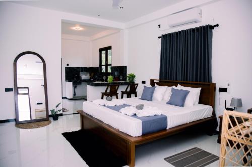 a bedroom with a large bed and a mirror at Paddy Breeze Villa in Batigama