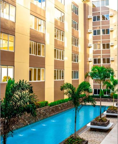 a building with a swimming pool in front of a building at The Cozy Place Stanford 2 in Silang