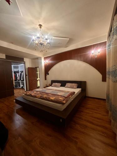 a large bed in a room with a chandelier at Kings Palace in Kathmandu