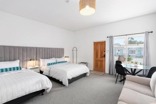a bedroom with two beds and a table and a couch at The Avalon in Mount Gambier
