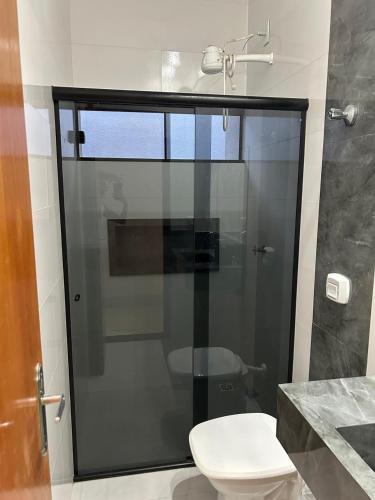 a bathroom with a glass shower with a toilet at Casa com 3 quartos aconchegante in Anápolis