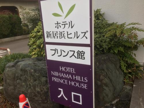 a sign for a hotel niumeka hills entrance house at Hotel Niihama Hills Prince House in Niihama