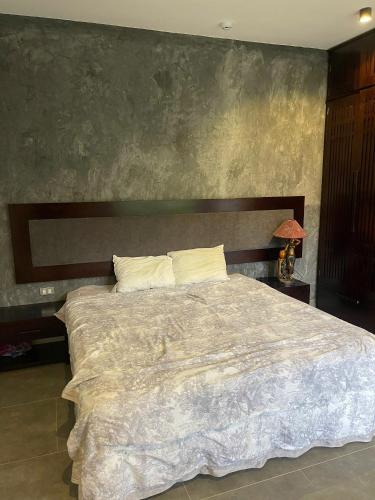 a bedroom with a large bed with a wooden headboard at emoi valley bavi in Ba Vì