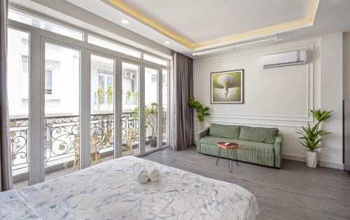 a bedroom with a bed and a couch and a balcony at V Living - Airport Stopover with Free Laundry in Ho Chi Minh City