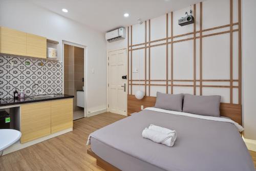 a bedroom with a large white bed and a bathroom at V Living - Airport Stopover with Free Laundry in Ho Chi Minh City