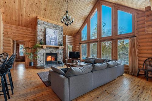 a living room with a couch and a fireplace at Fiddler Lake Resort - Deer 69 in Mille-Isles