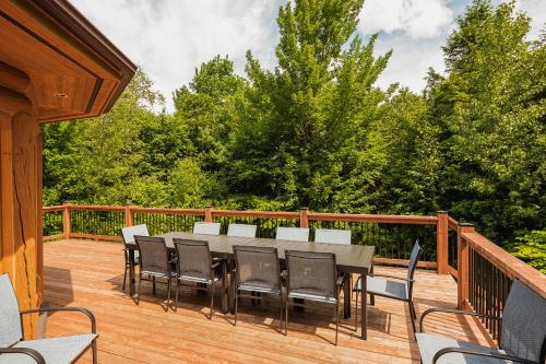 a wooden deck with a table and chairs on it at Fiddler Lake Resort - Deer 69 in Mille-Isles