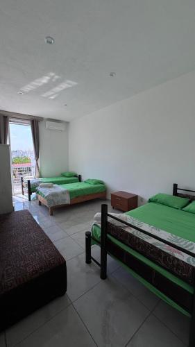 a room with three beds and a window at Home in Tequesquitengo in Tequesquitengo