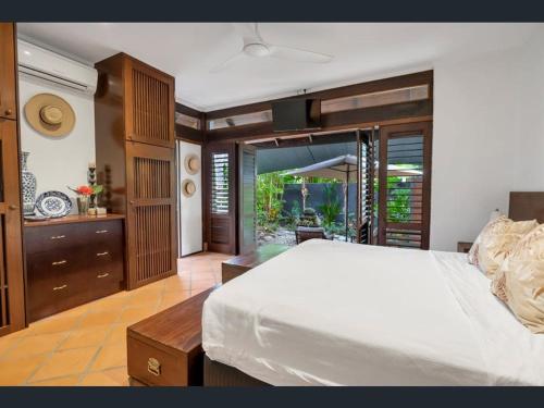 a bedroom with a large white bed in a room at Solander Beachfront with private beach access & pool in Port Douglas