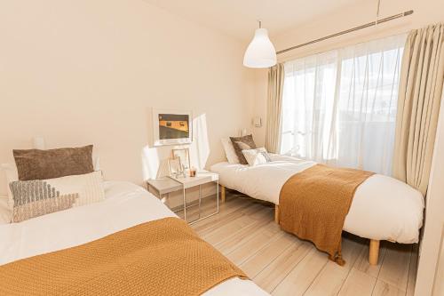 a bedroom with two beds and a window at Mi-Hotel Ikebukuro in Tokyo