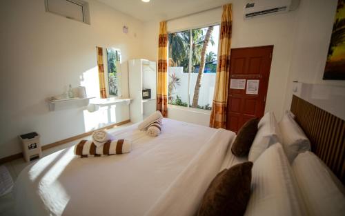 a bedroom with a large white bed with a window at Velana View at Mathiveri in Mathiveri