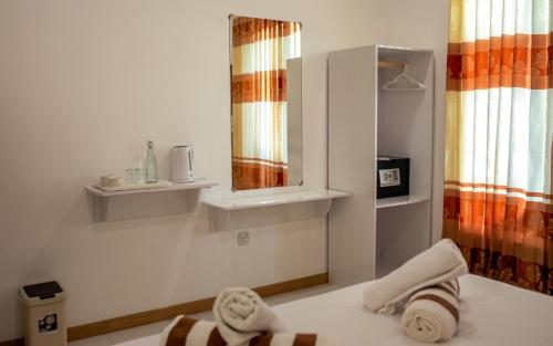 a bathroom with a mirror and towels on a bed at Velana View at Mathiveri in Mathiveri