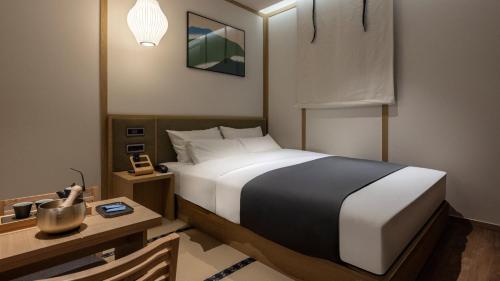 a bedroom with a bed and a desk and a bed sidx sidx sidx at Anook Ryokan Hotel Eunpyeong Bulgwang in Seoul