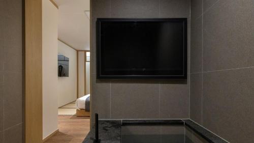 a flat screen tv on a wall in a room at Anook Ryokan Hotel Eunpyeong Bulgwang in Seoul