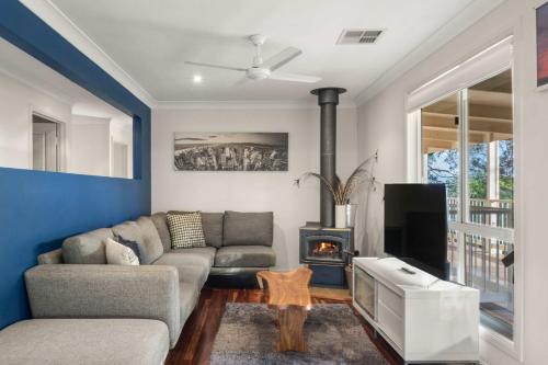 a living room with a couch and a fireplace at Hinterland Tranquil Escape with Beautiful Views in Ninderry